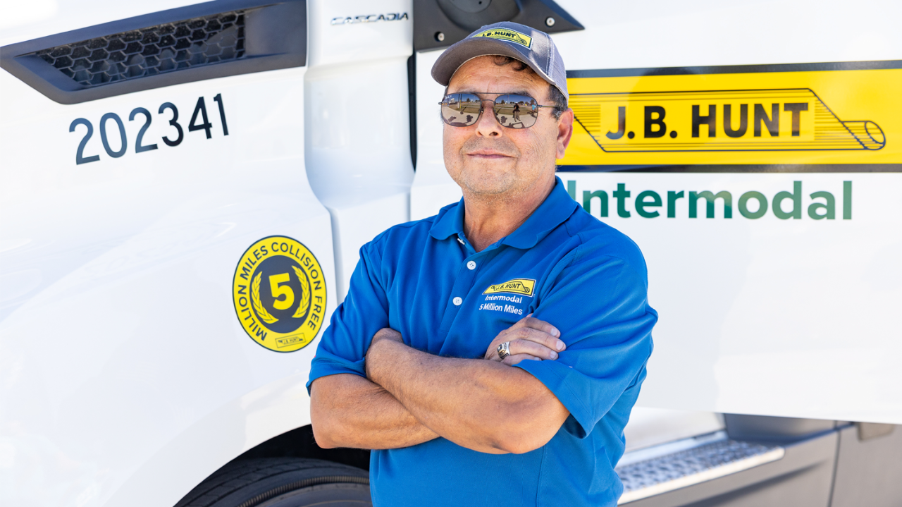 J.B. Hunt Intermodal Driver, Tony, stands in front of truck with arms crossed and smiling