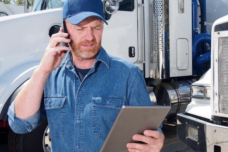 driver on phone holding tablet