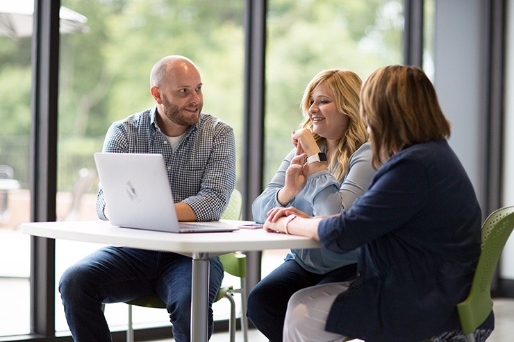 j.b. hunt employees sitting at a table and looking at a computer