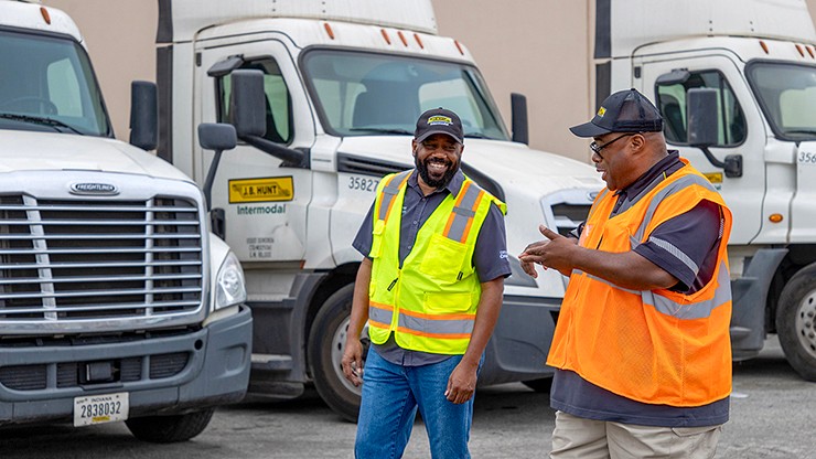 two drivers talking while walking to trucks