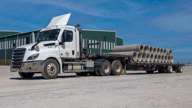 Dedicated Contract Services Truck Hauling Concrete Drainage pipes