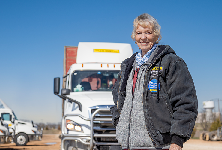 J.B. Hunt dedicated driver standing in front of a parked truck